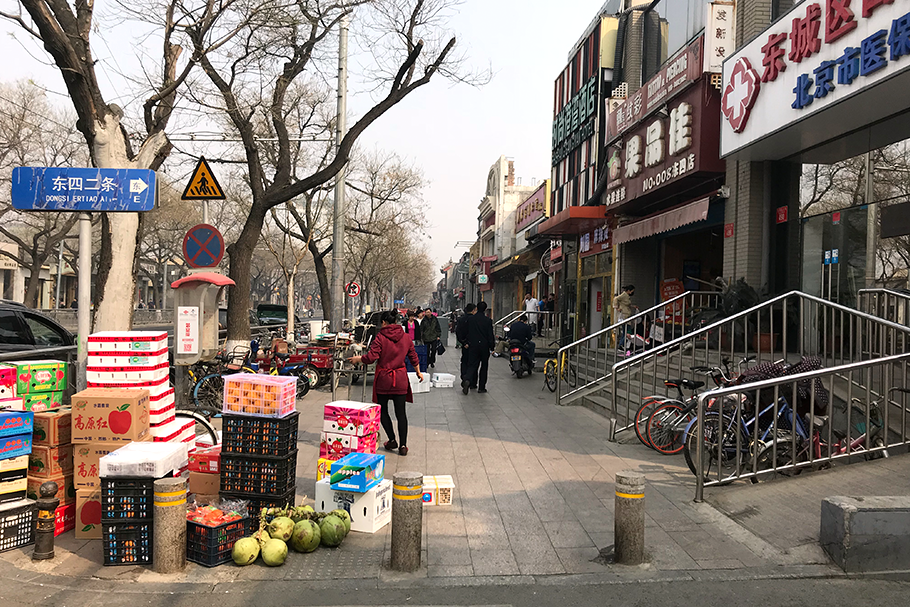 Comércio de rua nos edifícios na divisa entre o Dongsi hutong da avenida principal.