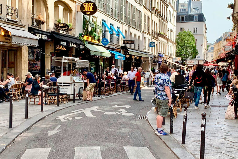Rue de Buci e Rue Montorgueil, duas das muitas ruas de Paris que acomodam veículos, mas são principalmente centros comunitários locais para residentes e visitantes.